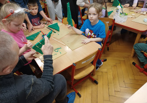 Grupa ludzi robiących choinki.