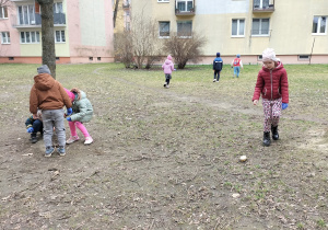 dzieci zbierają śmieci koło bloków