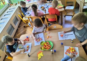 dzieci wykonują jesienne drzewo z kawałków kolorowego papieru