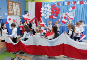 Dzieci z czwartej grupy trzymają flagi Polski.