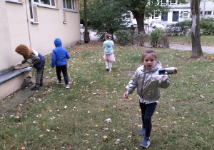 dzieci sprzątają teren kołobiblioteki