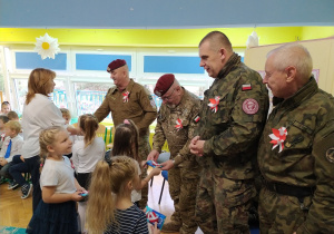 Dzieci z grupy najstarszej wręczają upominki żołnierzom.
