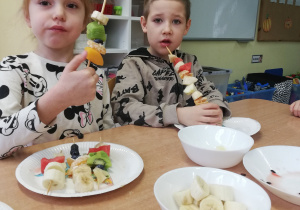 Dzieci jedzą owoce z wcześniej przygotowanych przez siebie szaszłyków.