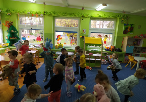 Dzieci tańczą ze swoimi misiami przy piosenkach dziecięcych.