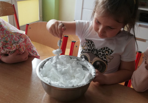 Dziewczynka miesza składniki na sztuczny śnieg.