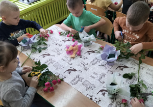 dzieci wycinają pojedyńcze kwiaty do komponowania bukietów