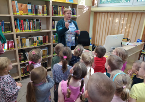 Pani bibliotekarka pokazuje kartę czytelnika.