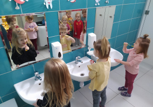 Dzieci szczotkują swoje zęby.