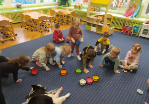 Dzieci ustawiają kolorowe miseczki dla pieska.