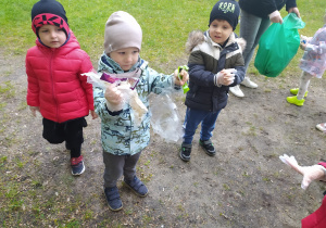 Dzieci pokazują jakie śmieci znalazły w okolicy przedszkola.