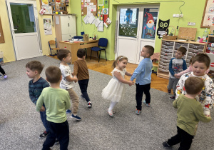 Dzieci tańczą i śpiewają przy piosenkach dziecięcych.