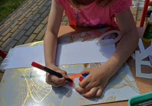 Dziewczynka pracująca nad zadaniem na tarasie.