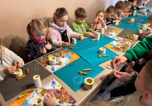 Przedszkolaki przygotowują silikonową foremkę na świeczkę.