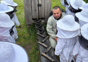 Dzieci oglądają poidełko dla pszczół.