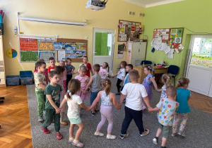 Dzieci tańczą wspólnie w kole.