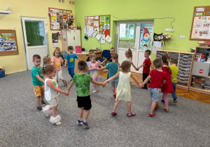 Dzieci tańczą w kole przy hitach dziecięcych.