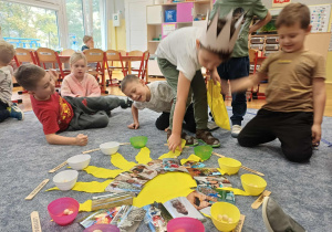 Wojtek wrzucający koralik do miseczki.