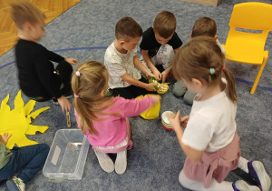 Dzieci składajace słoneczko urodzinowe.