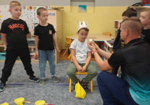 Symboliczne zdmuchiwanie świeczki przez jubilata.