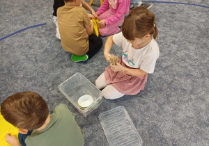 Dziewczynka składająca drewniane znaczniki z nazwami miesięcy.