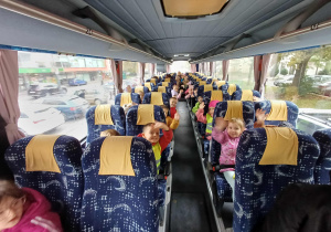 Zdjęcie grup dzieci siedzących w autokarze wracających po spektaklu.