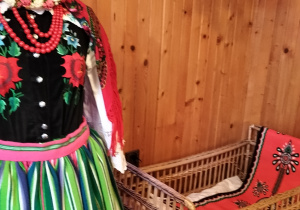 stroje ludowe i łóżeczko z wikliny