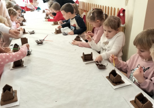 dzieci sklejają pierniki w domek