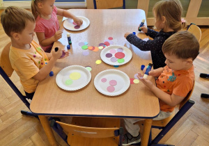 Dzieci wykonujące pracę plastyczną.