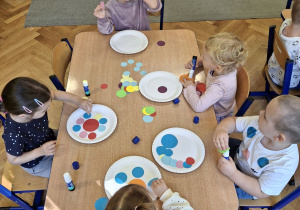 Dzieci wykonujące pracę plastyczną.