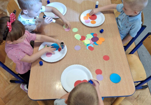 Dzieci wykonujące pracę plastyczną.