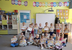 Dzieci prezentujące otrzymane dyplomy z okazji Dnia Przedszkolaka.