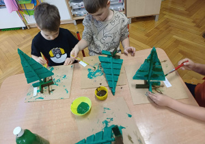 Dzieci malujące swoje choinki.