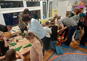 Grupa ludzi podczas warsztatów plastyczno-technicznych.