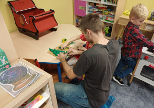 Rodzina pracująca w odosobnionym miejscu nad swoją ozdobą bożonarodzeniową.