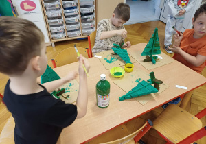 Dzieci malujące swoje choinki.