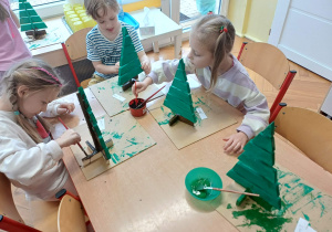 Dzieci ozdabiające świecidełkami swoje prace.