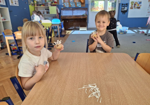 Dziewczynka i chłopiec prezentujący wykonane jeżyki.