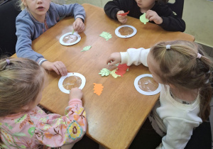 Dzieci wykonujące jesienną pracę plastyczną.