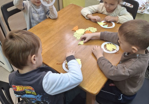 Dzieci wykonujące jesienną pracę plastyczną.