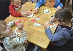 Dzieci wykonujące jesienną pracę plastyczną.