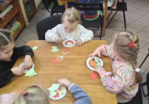Dzieci wykonujące jesienną pracę plastyczną.