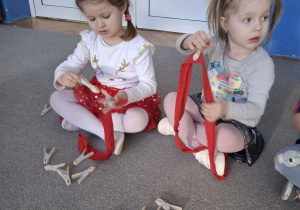 Dzieci przypinają klamerki na szarfę.