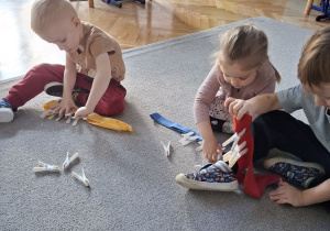 Dzieci przypinają klamerki na szarfę.