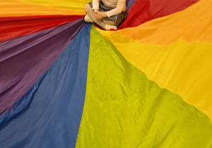 Dziewczynka siedzi na środku chusty.