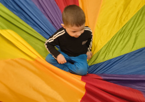 Chłopiec siedzi na środku chusty.