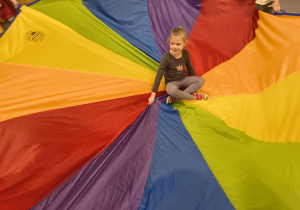 Dziewczynka siedzi na środku chusty.