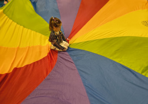 Dziewczynka siedzi na środku chusty.