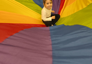 Dziewczynka siedzi na środku chusty.