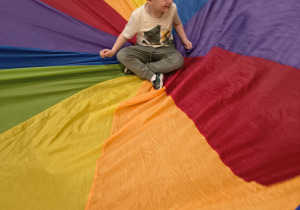 Chłopiec siedzi na środku chusty.