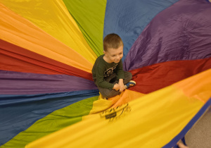 Chłopiec siedzi na środku chusty.